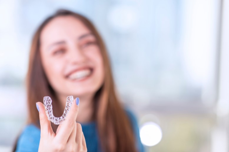 A person in Ealing smiling confidently, showcasing the discreet and effective transformation achieved with Invisalign, perfect for modern lifestyles.